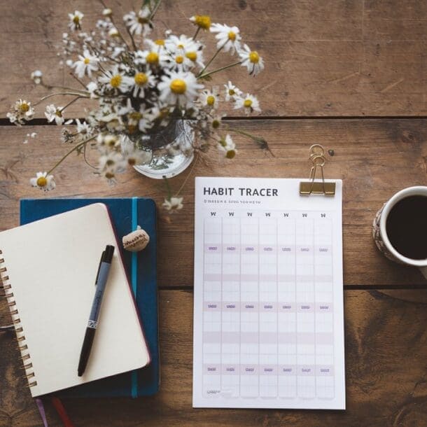 A habit tracker on a wood table. Person is focused on Building Good Habits and Beating Bad Ones