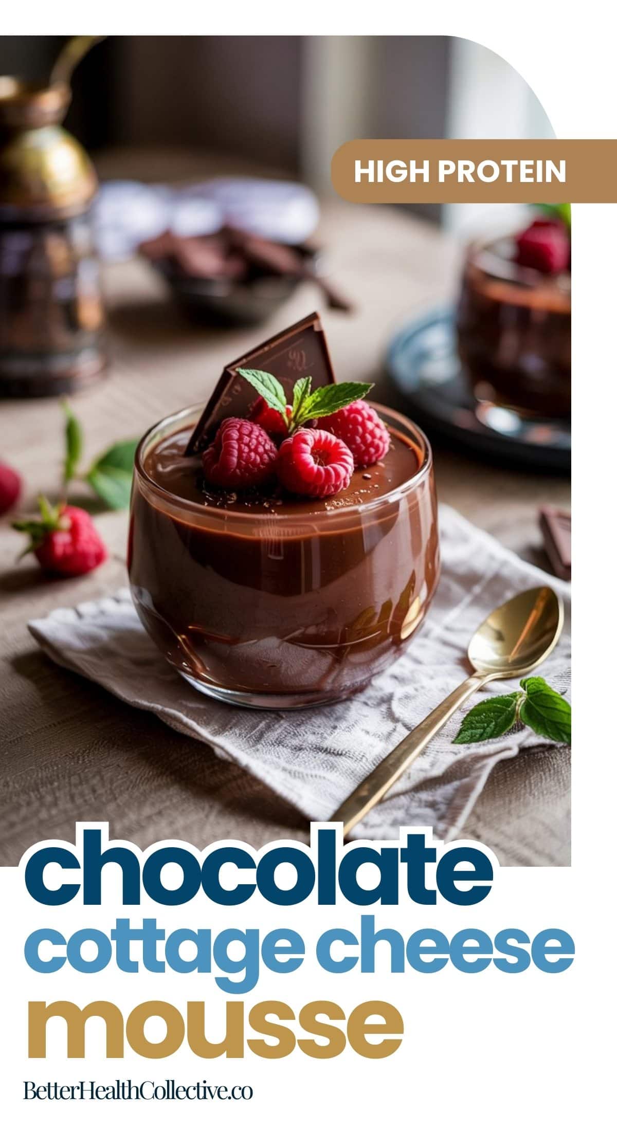 A glass of cottage cheese chocolate mousse is topped with raspberries, a mint sprig, and a chocolate square, seated beside a gold spoon. This no-bake dessert highlights “high protein” and “chocolate cottage cheese mousse.”.