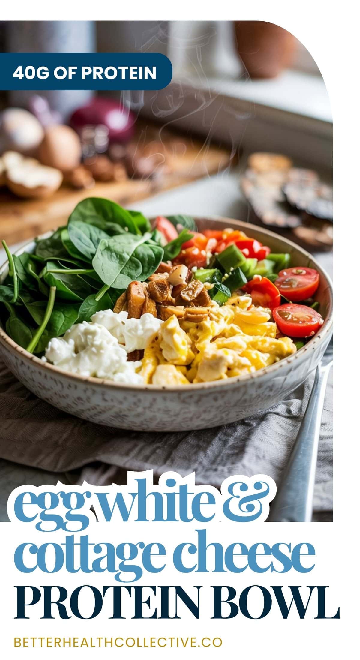 A protein bowl filled with egg whites, cottage cheese, spinach, cherry tomatoes, cucumber, and nuts sits on a table. Text reads, “40g of protein. Egg white & cottage cheese protein bowl. wellnestguide.com.”.
