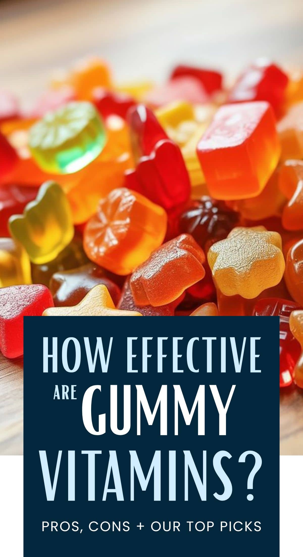 A pile of colorful gummy vitamins on a wooden surface, with a text overlay that reads: How effective are gummy vitamins? Explore gummy vitamin benefits, pros, cons + our top picks.