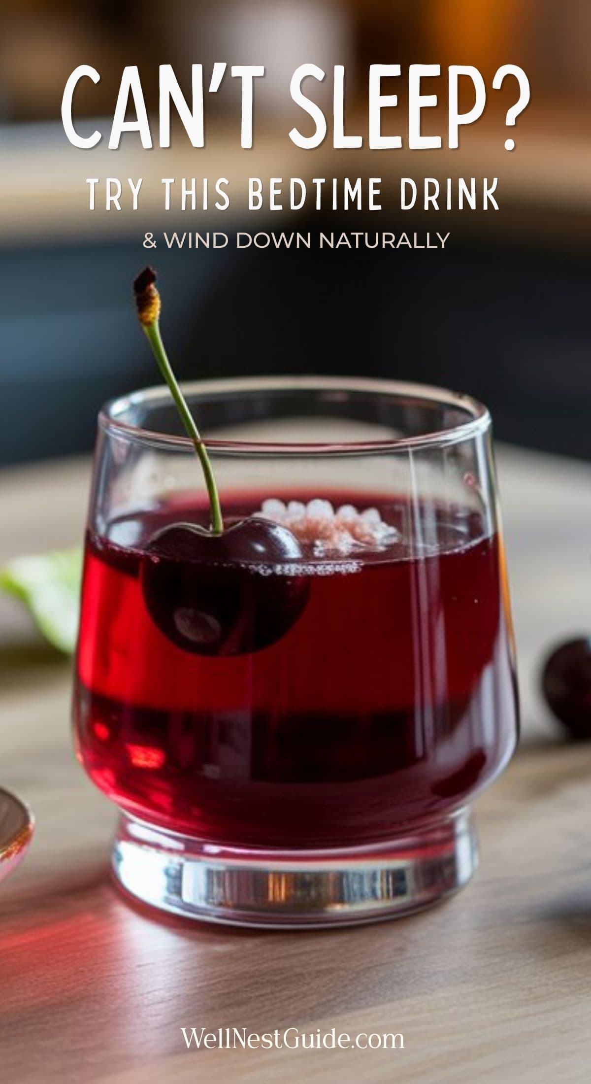 A glass of red adrenal cocktail for sleep with a cherry garnish sits on a wooden table. Text above reads: CANT SLEEP? Try this bedtime drink & wind down naturally. Website WellNestGuide.com is shown at the bottom.